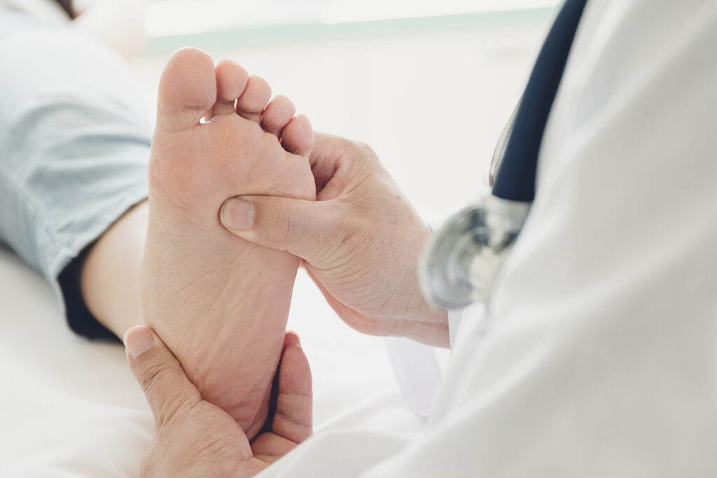 Medical professional examining worsening flat feet symptoms with a veteran